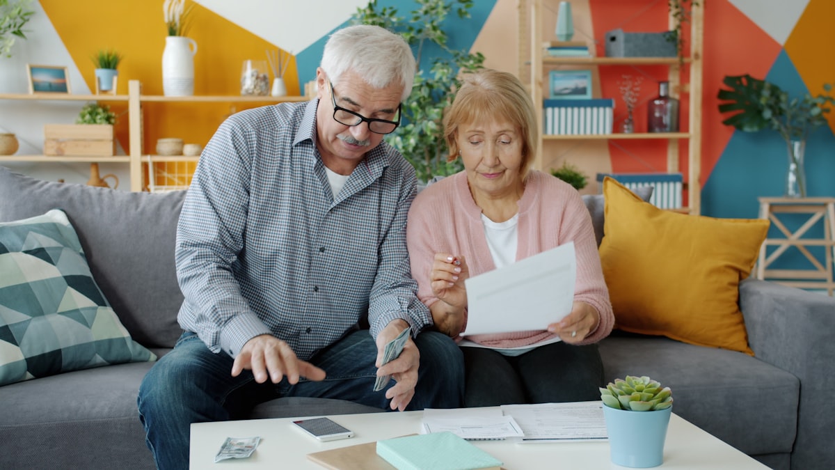 Senior couple reviewing Medicare enrollment paperwork together at home